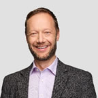 A person with a beard smiling Description automatically generated
